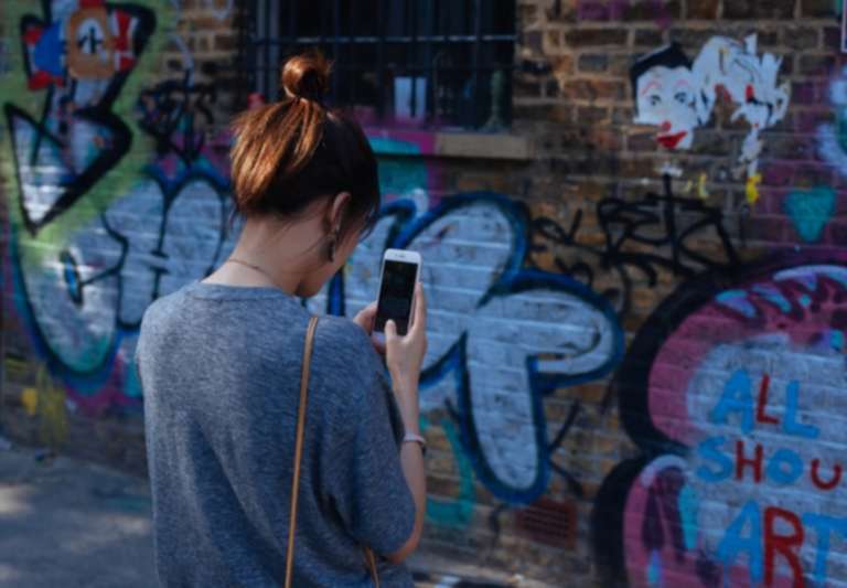 Girl taking a photo of an art wall