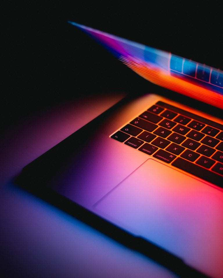 Macbook is partially open on table.