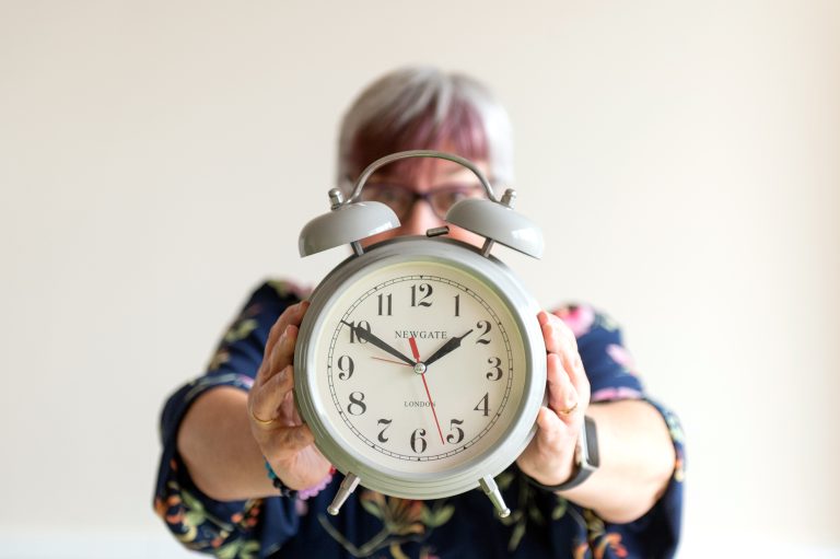Journalist & PR consultant Fiona Scott holding an old-fashioned alarm clock