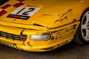 Yellow racing Ferrari with broken bumper
