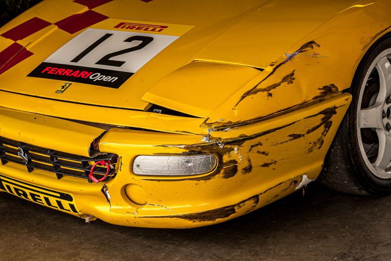Yellow racing Ferrari with broken bumper