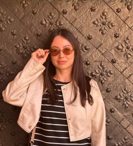 Portrait of Nataliia Sinelnikova, a Ukrainian entrepreneur and natural leader, the woman who builds teams that thrive under pressure, smiling confidently against a neutral background.